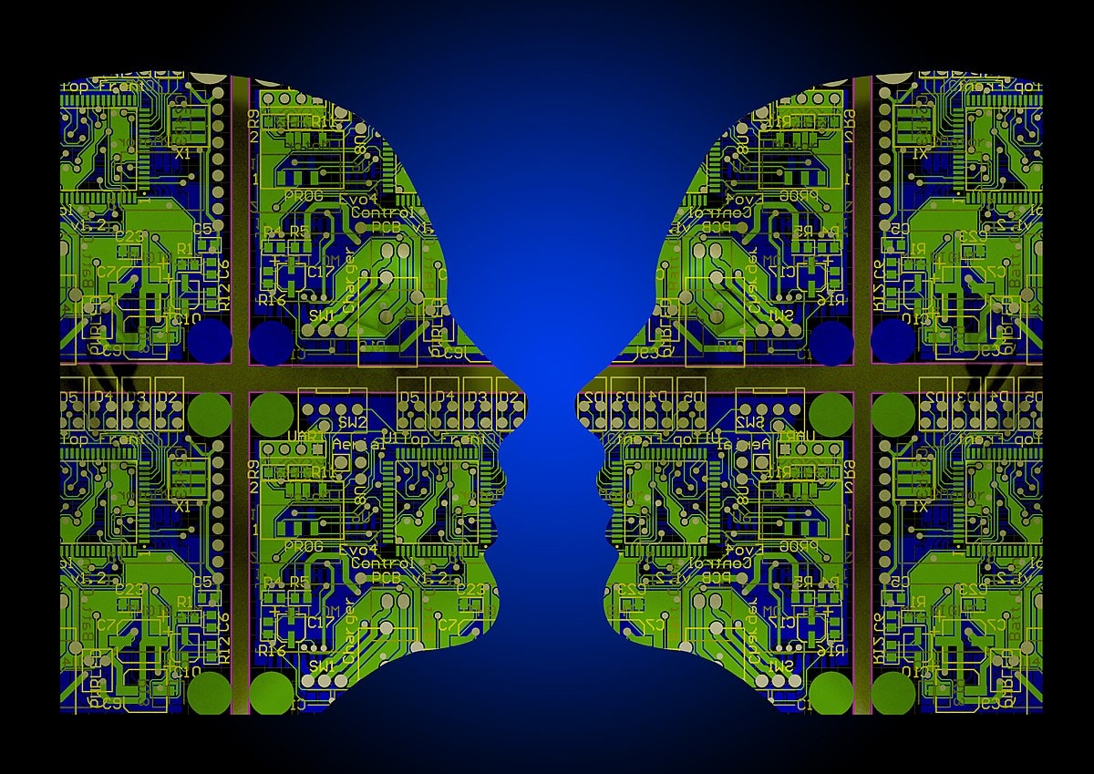 Two human profiles made of green circuit board patterns face each other on a blue and black gradient background, symbolizing technology, artificial intelligence, and human-machine interaction.
